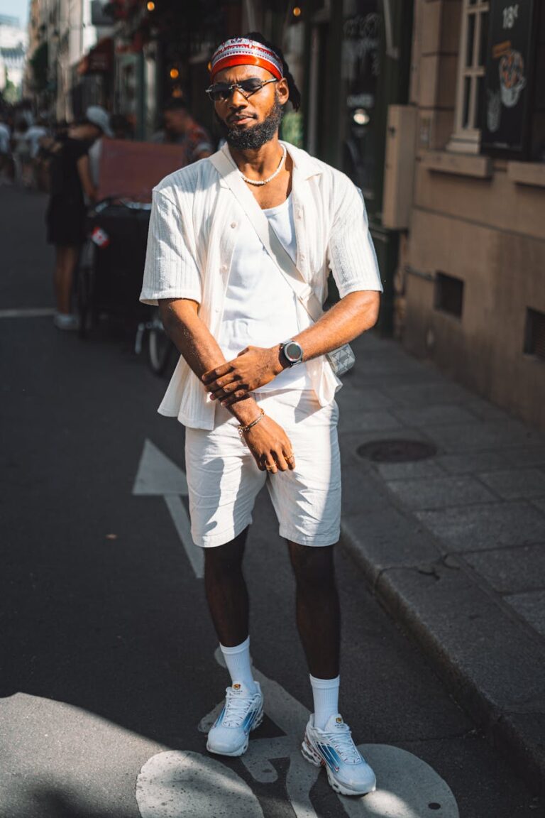 a man in white shorts and a white shirt standing on the street
