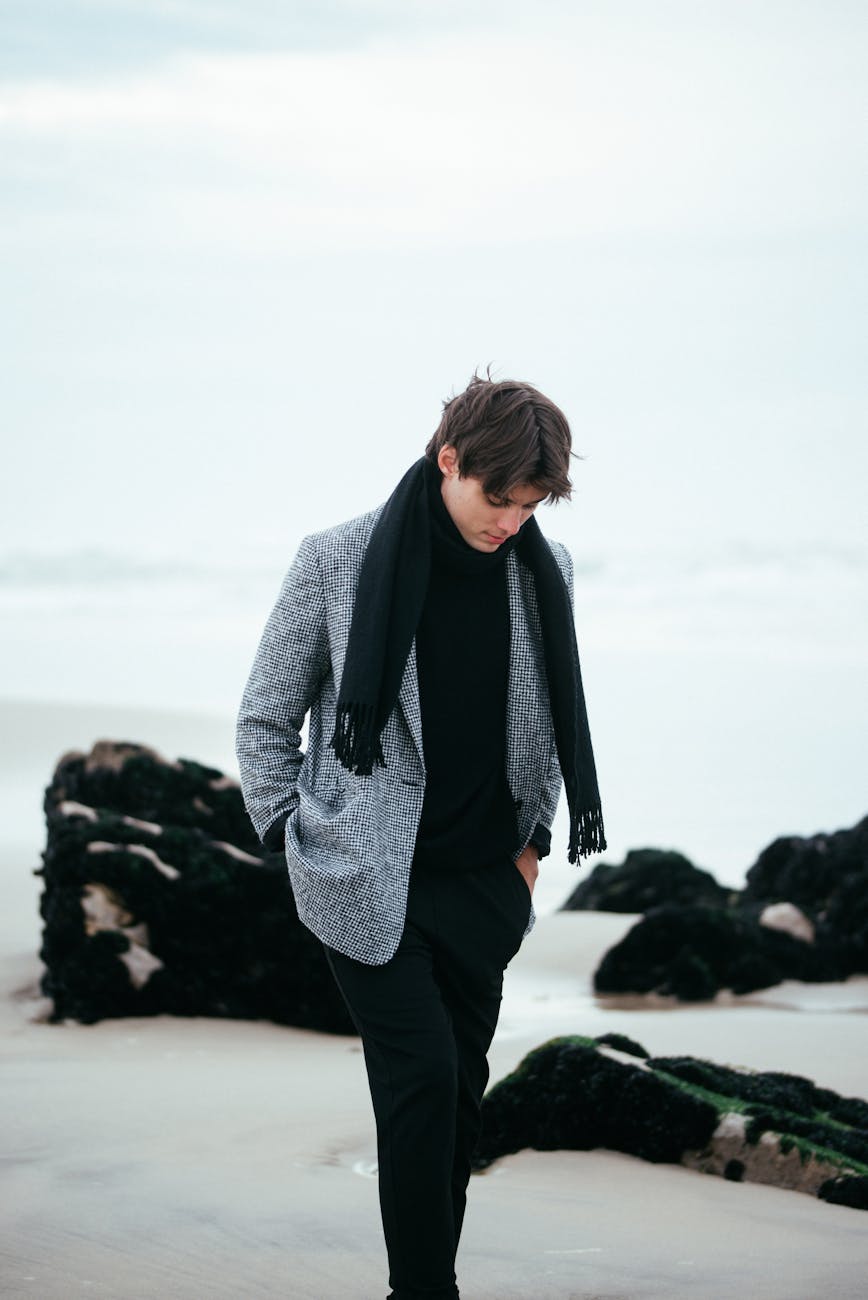 fashionable man strolling on a rocky beach
